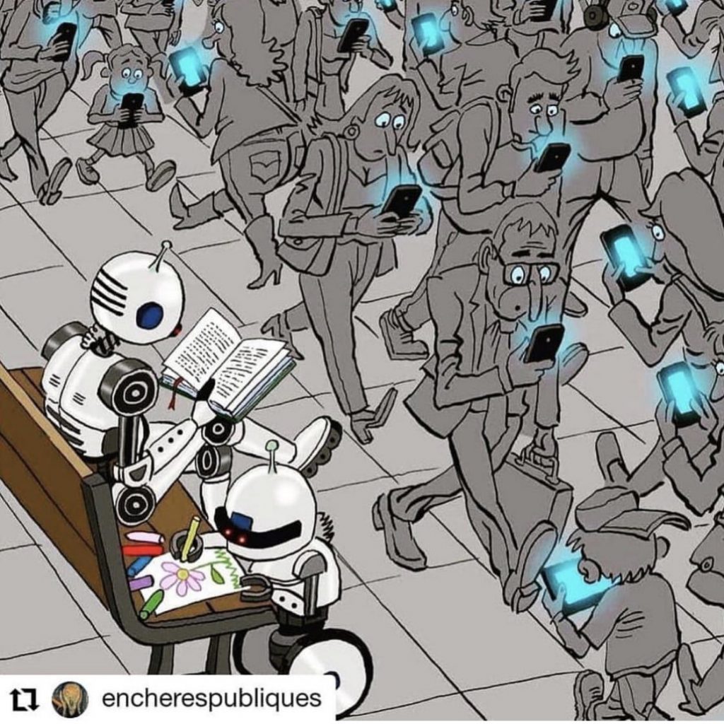Humans staring blindly at their smartphones and tablets while two robots sit on a bench reading and drawing a picture.