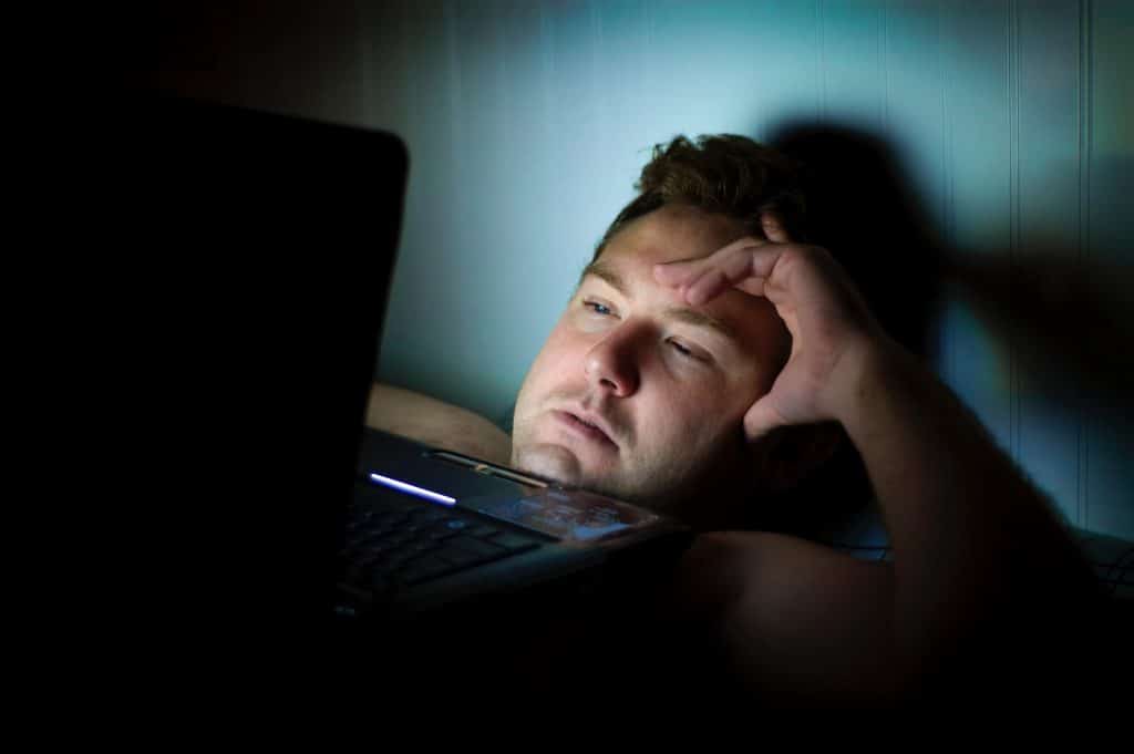dude in dark looking at computer