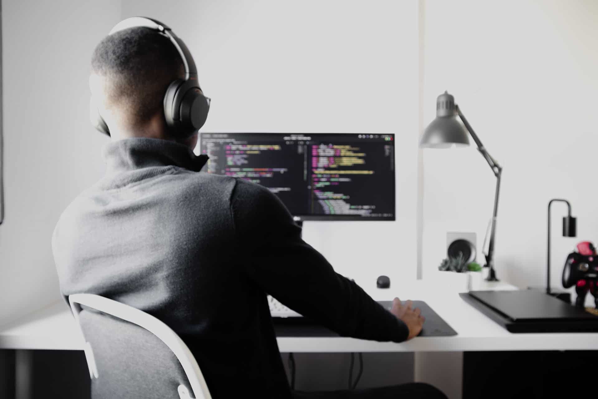 Man coding at desk while focused