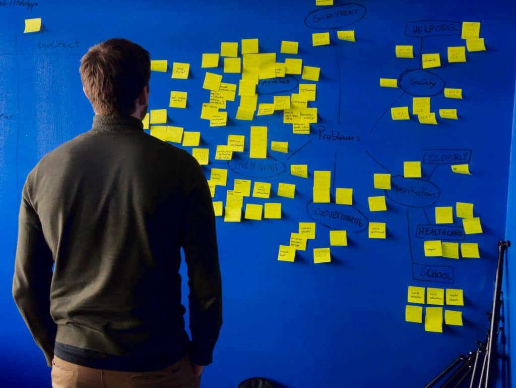 man standing in front of a board with stickies for brain dump