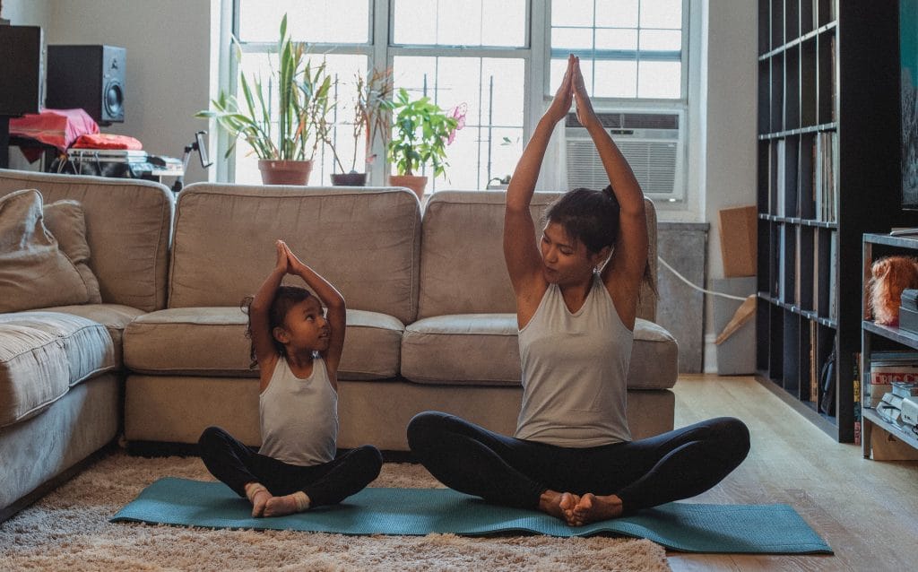 mother and daughter practicing yoga and stretching together