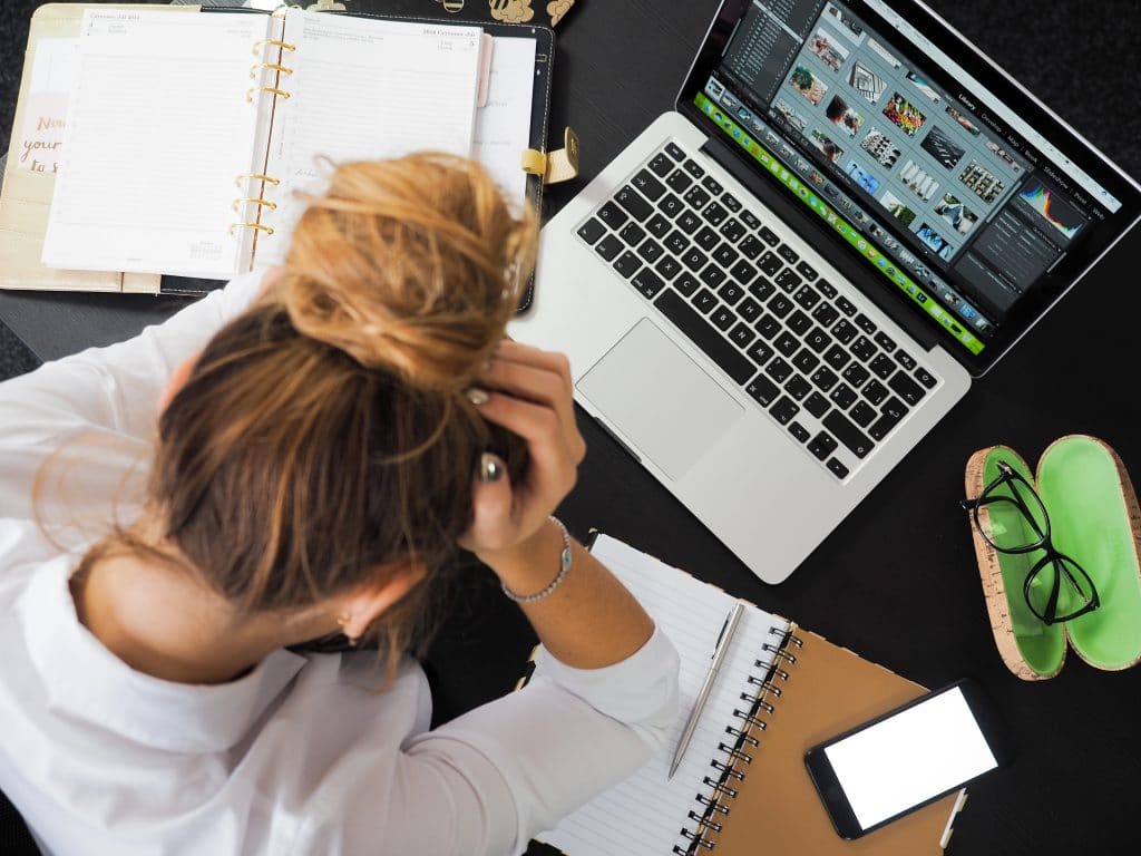 stressed worker at messy desk overwhelmed with tasks