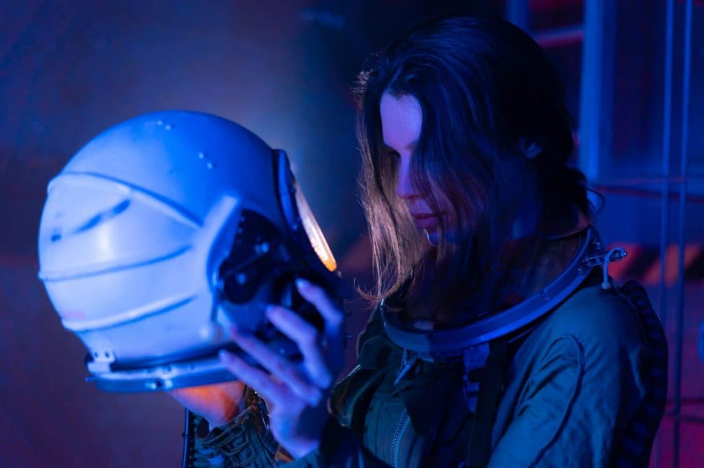 Female astronaut looking into helmet blue light truth