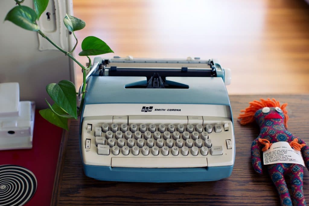 Electronic typewriter on desk with child's toy work family balance