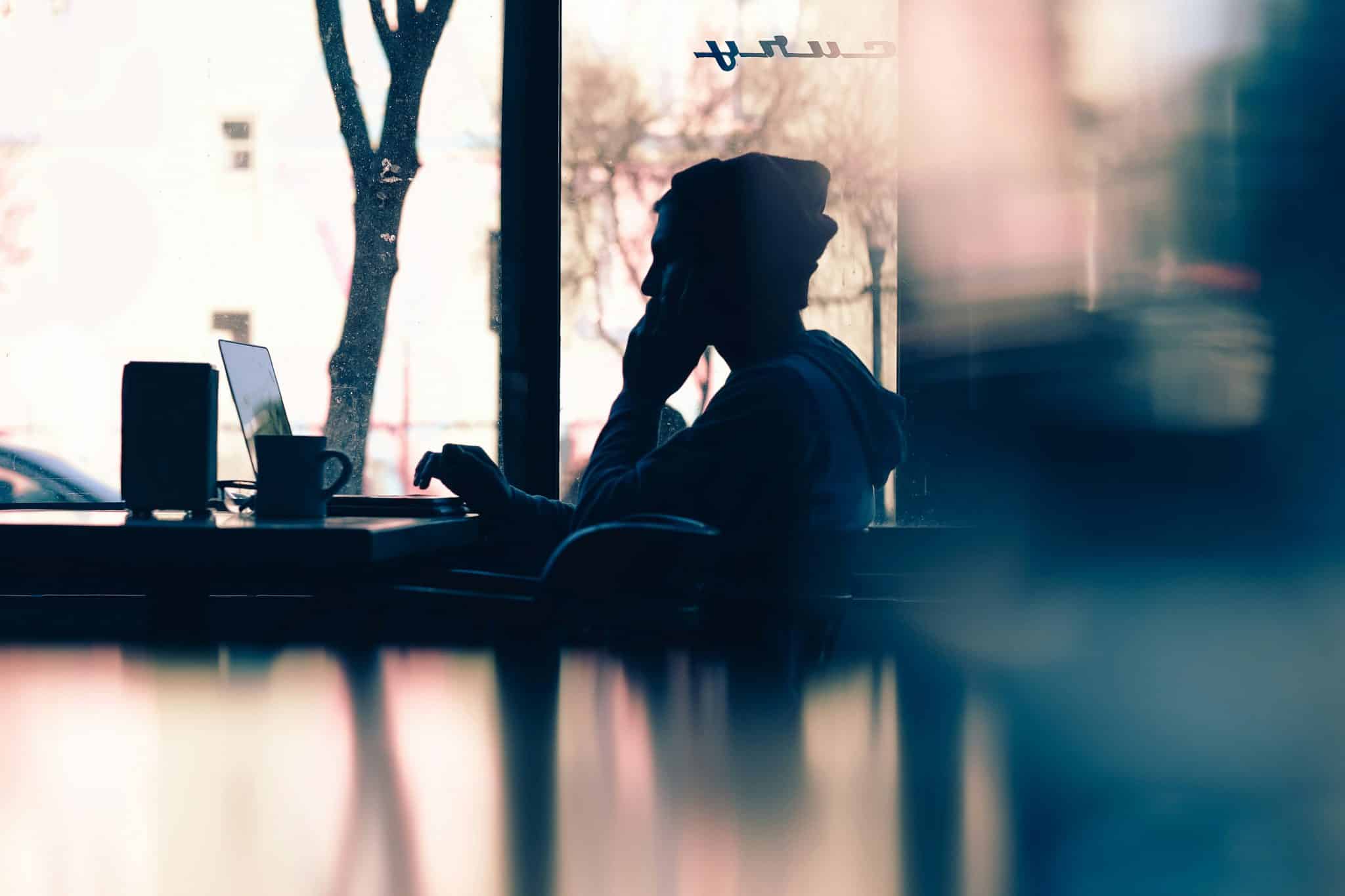 Silhouette of a person working late on a laptop, visually capturing the concept of motivation vs discipline in deep focus work.