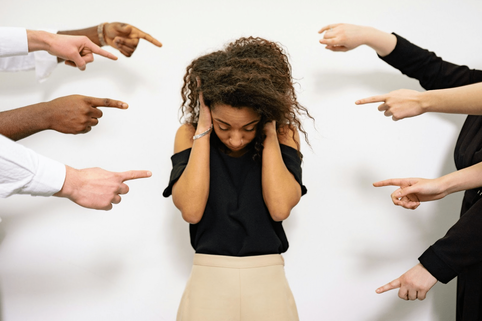 Woman covering her ears to block out noise, illustrating ADHD overstimulation in overwhelming environments.