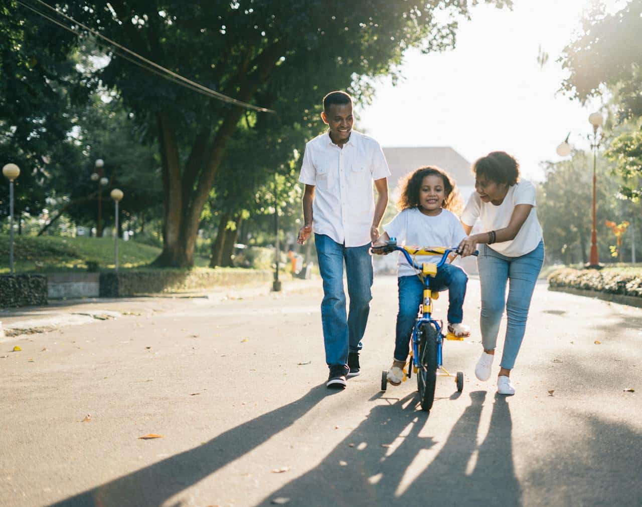 Family teaching child to bike — outdoor quality time and screen-free bonding.