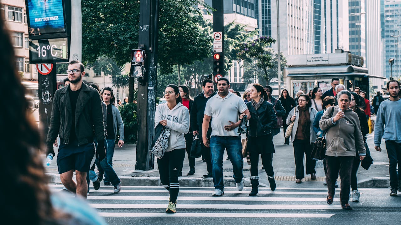 People walking across a busy city crosswalk representing soft discipline and sustainable productivity in daily life