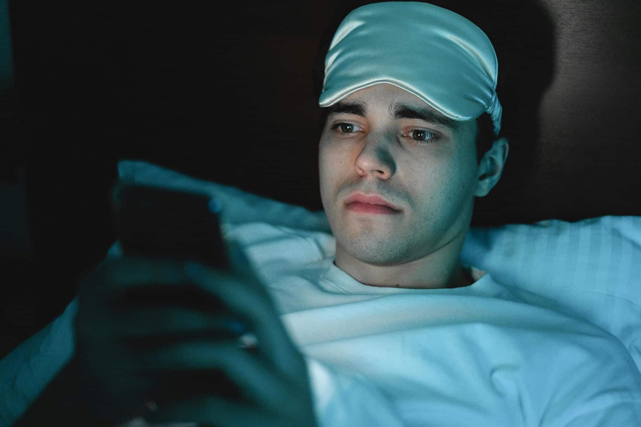 in bed staring at phone screen